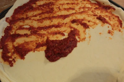 Wierzch ciasta smarujemy sosem pomidorowym do pizzy